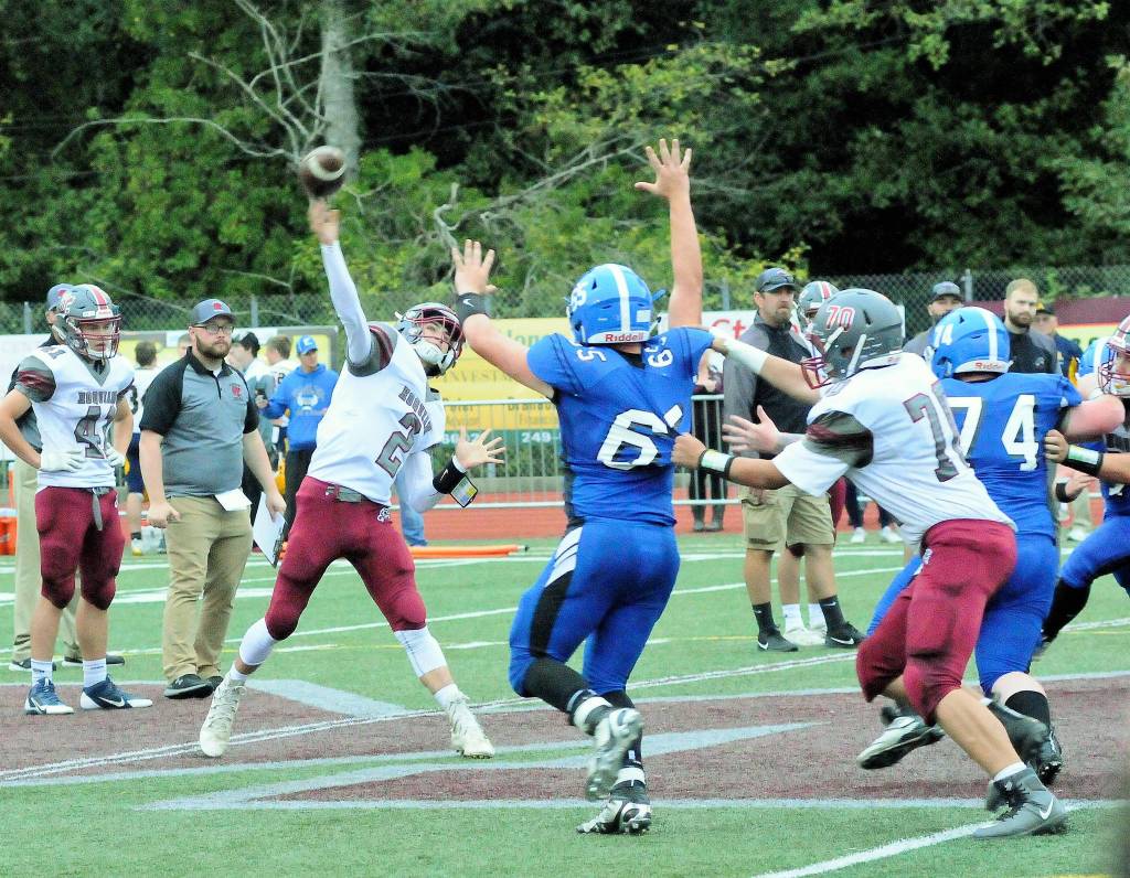 Hoquiams Cayden Kempf delivers a pass while Elmas Tucker Potts (65) applies pressure from the edge at the Jamboree on Friday in Montesano. (Hasani Grayson | Grays Harbor News Group)