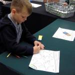 Kat Bryant | Grays Harbor News Group                                Associated Arts of Ocean Shores invited children to color pictures of beach images for a contest during the annual show last weekend. Here, 6-year-old Killian from Bonney Lake works on his masterpiece.