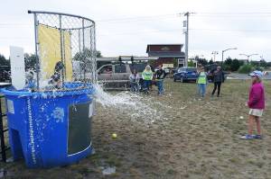 OS Fire Capt. Mike Thuirer was dunked multiple times by 9-year-old Shayna, a lacrosse player, during the Paddle the Shores event Saturday at Oyhut Bay.