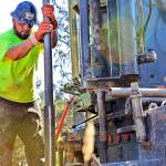 Photo by ASHLEY NERBOVIG | CHINOOK OBSERVER                                Drilling Supervisor Brad Wright stands clear as Driller Sam Moreno sets the drill in place. The men work for Hart Crowser and were in Tokeland to drill out samples of the earth where the Shoalwater Bay Indian Tribe plan to erect a tsunami evacuation tower.
