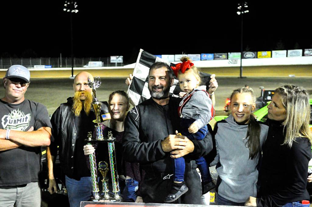 (Hasani Grayson | Grays Harbor News Group) Scott Fritts, center, stands with his trophy after winning the street stock division at Grays Harbor Raceway on Saturday. Fritts came into the final race of the season 10 points behind the division leader.