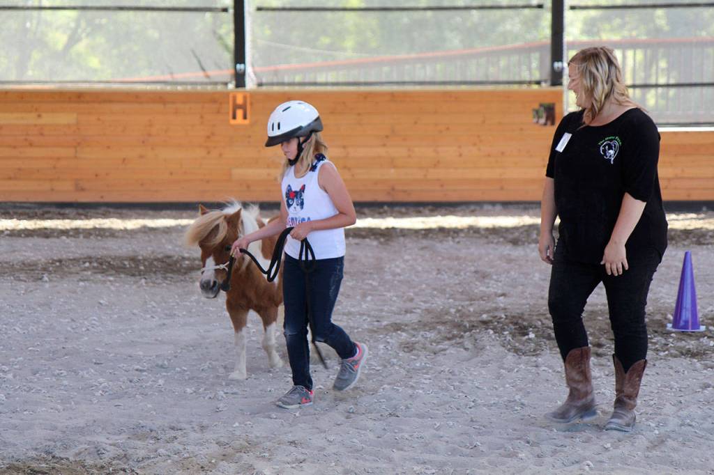 Michael Lang | Grays Harbor News Group                                Makenzie Cook, 11, of Westport, leads Scribbles around the arena under the watchful eye of Horse Prayer volunteer Jenny LaDue.