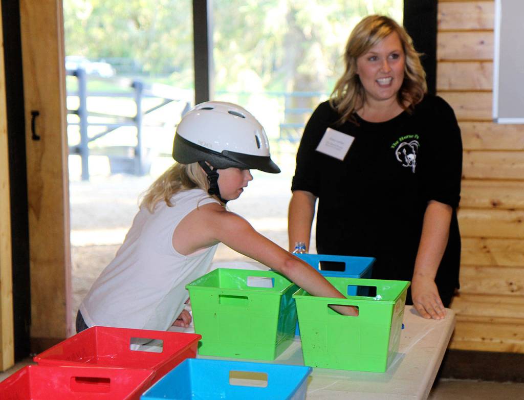 Michael Lang | Grays Harbor News Group                                Makenzie Cook, 11, creates a nutritionally balanced treat for a horse with the help of volunteer Jenny LaDue.