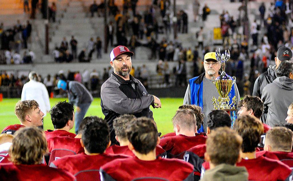 Hoquiam head coach Jeremy McMillan talks to his team while standing next to the Myrtle Street Rivalry Trophy after Hoquiams 56-3 win over Aberdeen on Friday night at Olympic Stadium. (Hasani Grayson | Grays Harbor News Group)