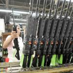 Sergio Pereira adds a completed Colt rifle to a rack of newly assembled guns at the company headquarters in West Hartford, Connecticut. The company said Thursday it was suspending production of AR-15 rifles for the civilian market. (Michael McAndrews/Hartford Courant)