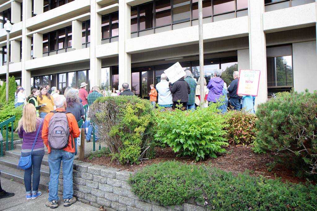 Aberdeen freshman Will Boling (center, holding microphone) reads a statement to the crowd Friday, Sept. 20, in front of the county administration building in Montesano as part of a global climate strike. (Michael Lang | Grays Harbor News Group)