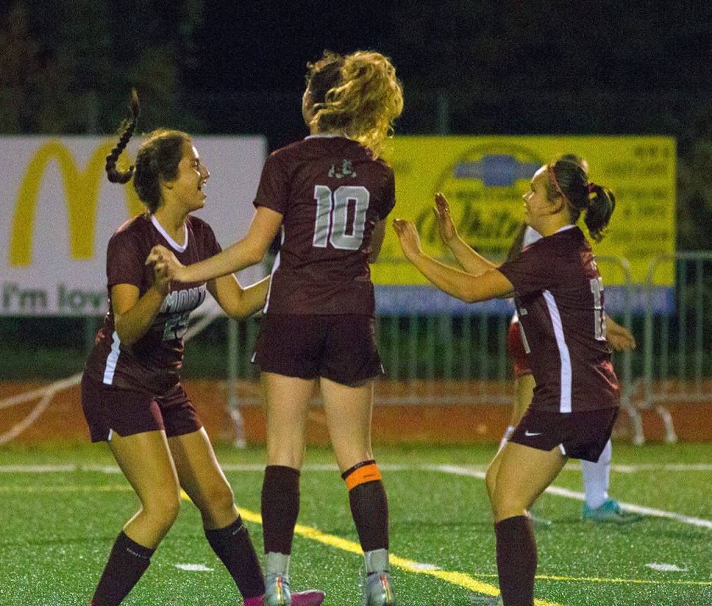 Montesanos Elleah Jones, left, celebrates with Brooke Streeter, middle, and Izabel Cope after scoring a goal in the 25th minute of the first half of a match against Hoquiam. (Hasani Grayson | Grays Harbor News Group)