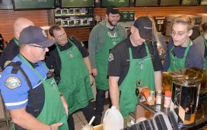 Cole Streeter, right, gave a crash course in latte-making at the Aberdeen Coffee with a Cop event. From left are Officer George Kelly, Lt. Dale Green, Aberdeen Mayor Erik Larson and Officer Gary Sexton.