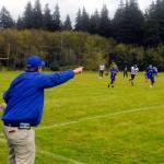 Lake Quinaults Jesus Mendoza returns an interception while head coach Melvyn Houtz directs him toward open space from the sidelines against Clallam Bay on Saturday. (Hasani Grayson | Grays Harbor News Group)