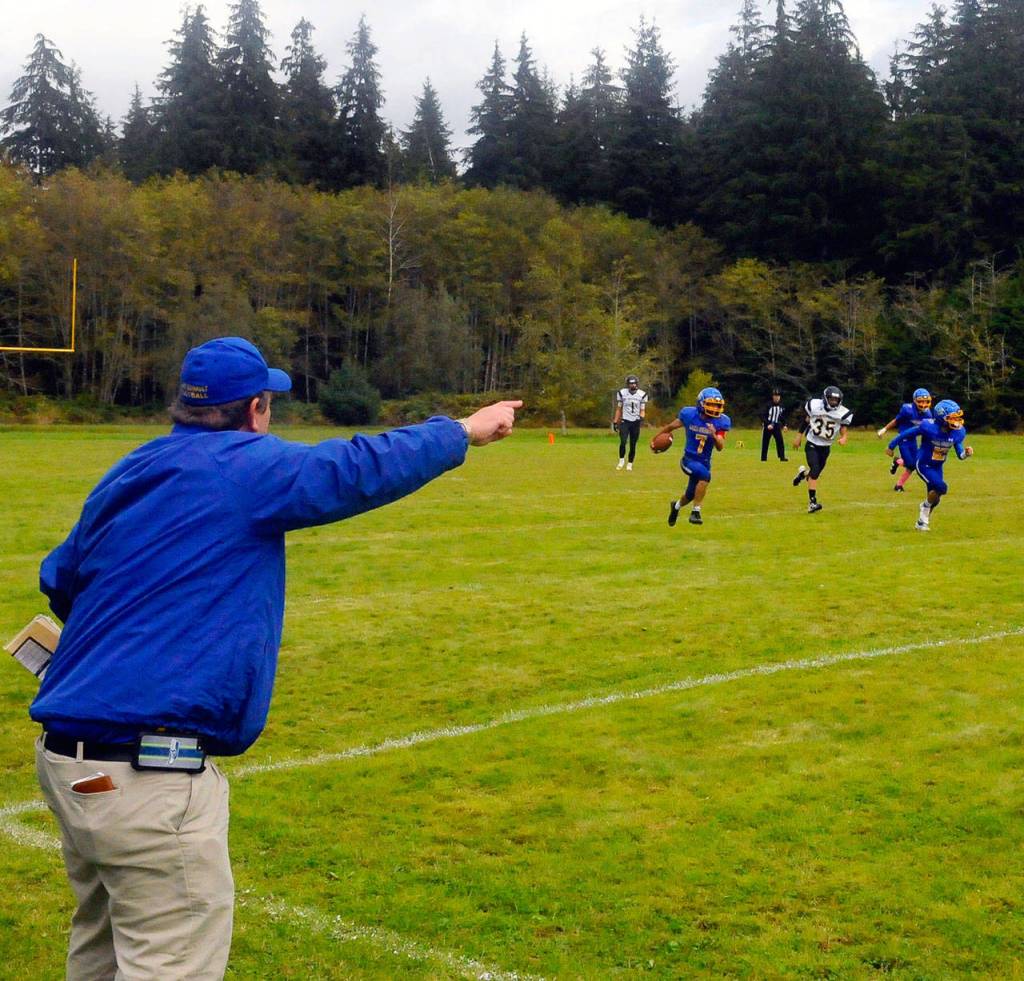 Lake Quinaults Jesus Mendoza returns an interception while head coach Melvyn Houtz directs him toward open space from the sidelines against Clallam Bay on Saturday. (Hasani Grayson | Grays Harbor News Group)