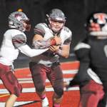 Hoquiam quarterback Dane McMillan, left, hands the ball off to running back Matt Brown during the Grizzlies 62-0 win over the Beavers on Friday. Hoquiam hosts county-rival Elma in a critical league contest at 7 p.m. on Friday. (Hasani Grayson | Grays Harbor News Group)
