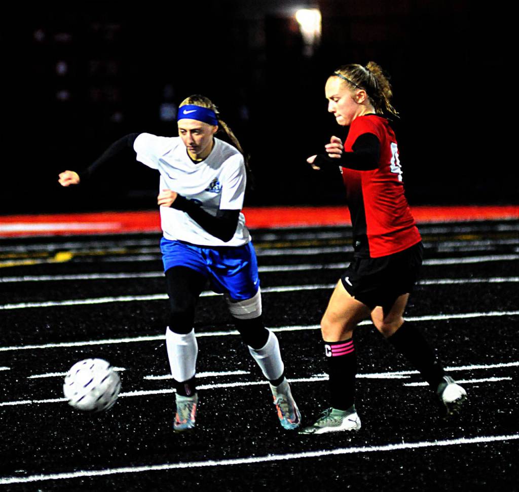 Elmas Jillian Bieker, left, gets around Tenino midfielder Megan Letts in the first half of a match on Thursday. (Hasani Grayson | Grays Harbor News Group)