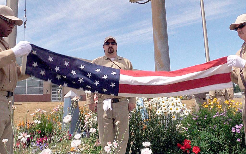 DEPARTMENT OF CORRECTIONS FILE PHOTO                                Incarcerated veterans unfold the American flag during a flag-raising ceremony at Stafford Creek Corrections Center.