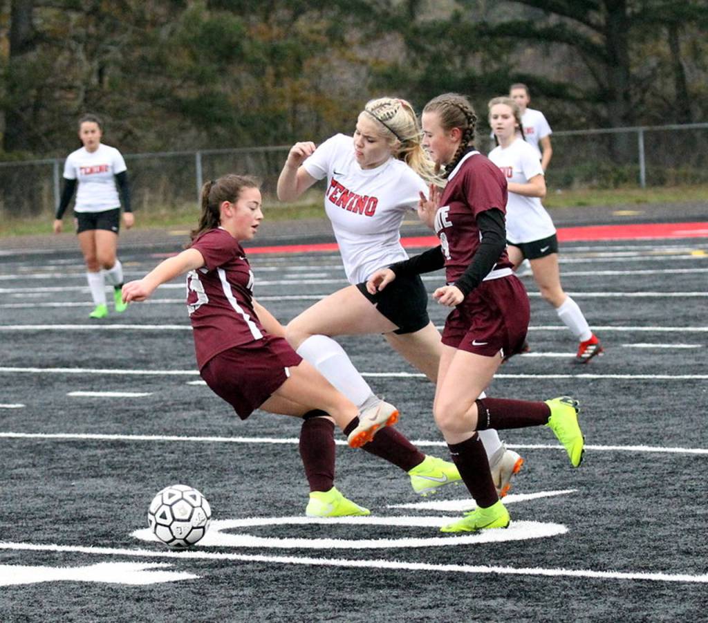 Montesanos Jaiden King, left, and Cassadie Golding, right, defend against Teninos Morgan Miner during Saturdays district title game at Tenino High School. (Photo by Shawn Donnelly)