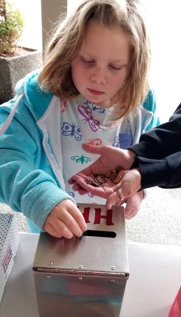 Photo courtesy Katie Barr                                Young Marcie Russel broke open her piggy bank and donated her coins to Food Ball at the Hoquiam Swansons store this past week.