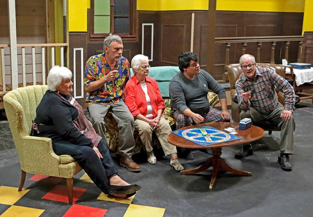 Nick (Chris Fruto, second from right) tries to guide his grandparents (from left, Louise Hoover, Judy Ball, Eddie Logue and Keith Krueger) through a game of Trivial Pursuit.