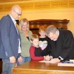 Judge Stephen Brown (right) signs an adoption certificate as Sean (from left) and Terri Robles adopt Eric and Julianna on Friday during the National Adoption Day ceremony at Grays Harbor County Superior Court in Montesano. (Michael Lang | Grays Harbor News Room)