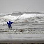 En garde! An early morning fisherman defies rough seas at low tide in Ocean Shores.