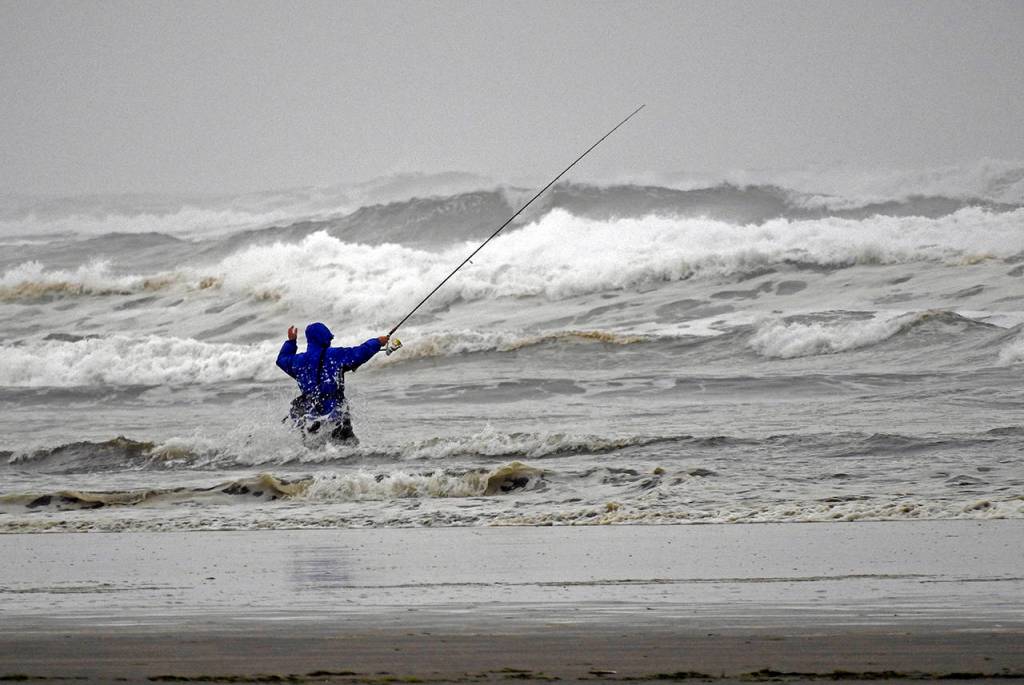 En garde! An early morning fisherman defies rough seas at low tide in Ocean Shores.