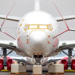 The nose section of a 737 MAX, framed by the wingtips of neighboring 737s, have their engines, landing gear, and front nose sensors protected from the weather at the Grant County International Airport in Moses Lake. Nearly 200 completed Boeing 737 MAX airplanes, built for airlines worldwide, are currently parked at his Eastern Washington airport. (Mike Siegel /Seattle Times)