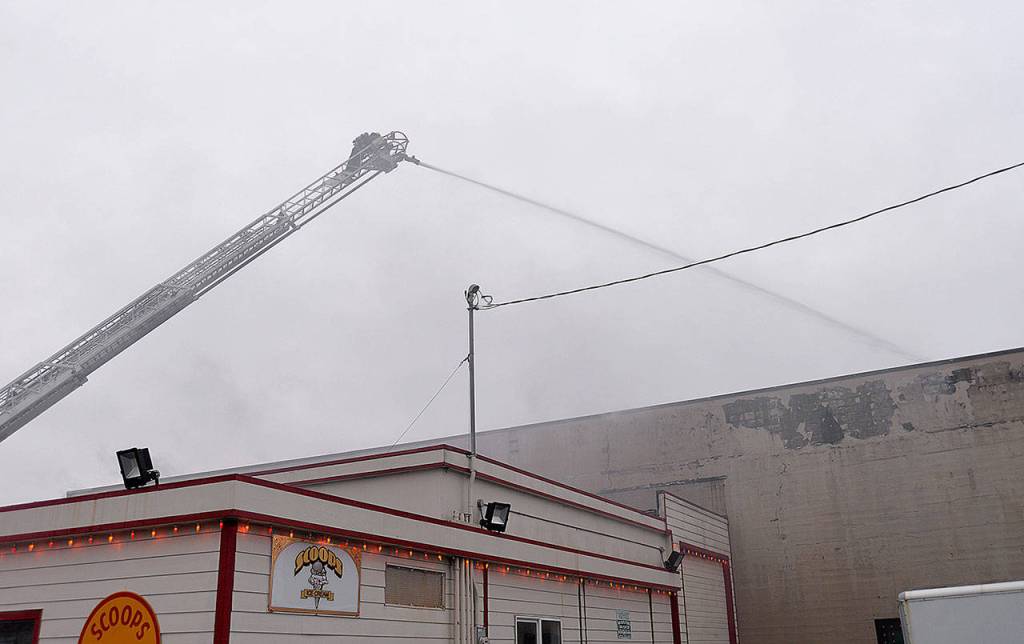 DAN HAMMOCK | GRAYS HARBOR NEWS GROUP                                An Aberdeen firefighter puts out hot spots on the fire at 115 W. Heron St. in downtown Aberdeen Saturday morning.
