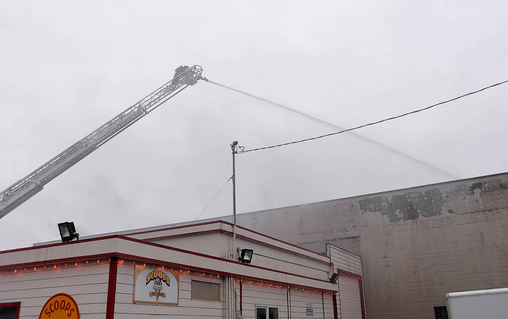DAN HAMMOCK | GRAYS HARBOR NEWS GROUP                                An Aberdeen firefighter puts out hot spots on the fire at 115 W. Heron St. in downtown Aberdeen Saturday morning.