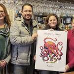 COURTESY WESTPORT WINERY                                Grays Harbor Historical Seaport board members Susan Dudley and Alex Kluh hold Kraken wine label art with winery owners Carrie Roberts and Kim Roberts. Kim Roberts designed the label art.