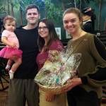 Mary Cooley, right, gives a gift basket to Anastasia Becraft, the museums 75,000th visitor, who was there Sept. 21 with her husband, Raymond, and their daughter, Loretta.