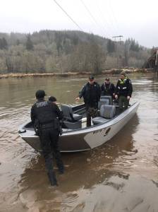 Grays Harbor Sheriffs Office deputies and Washington Department of Fish and Wildlife officers escort a suspect Saturday from the Wynoochee River. (Photo courtesy Undersheriff Brad Johansson)