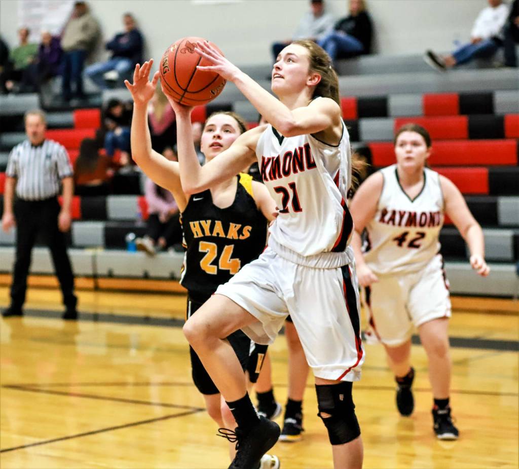 Raymond guard Kyra Gardner 21 goes up for a layup against North Beach defender Skyler Langston during Raymonds 79-25 win on Monday at Raymond High School. (Photo by Larry Bale)