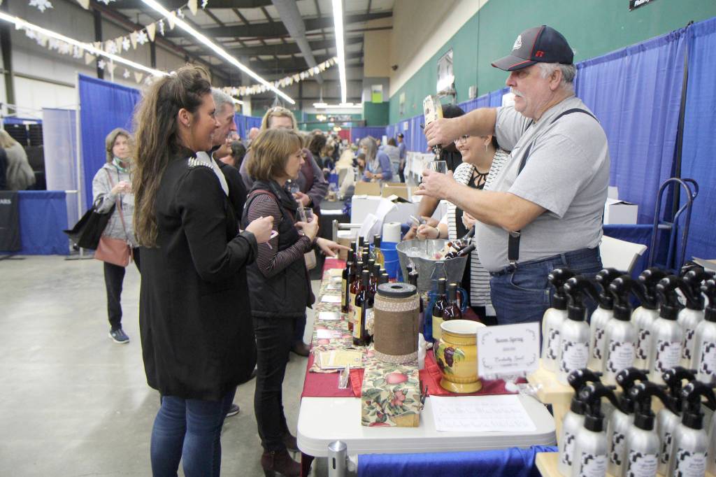 Michael Lang | Grays Harbor News Group                                 A vendor pours a sample for an attendee Saturday at the Winter Wine Festival in Elma.