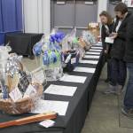 Cher Cole of Grayland (from left) and Judy Meeds of Castle Rock check out the auction table Saturday at the Winter Wine Festival in Elma. (Michael Lang | Grays Harbor News Group)