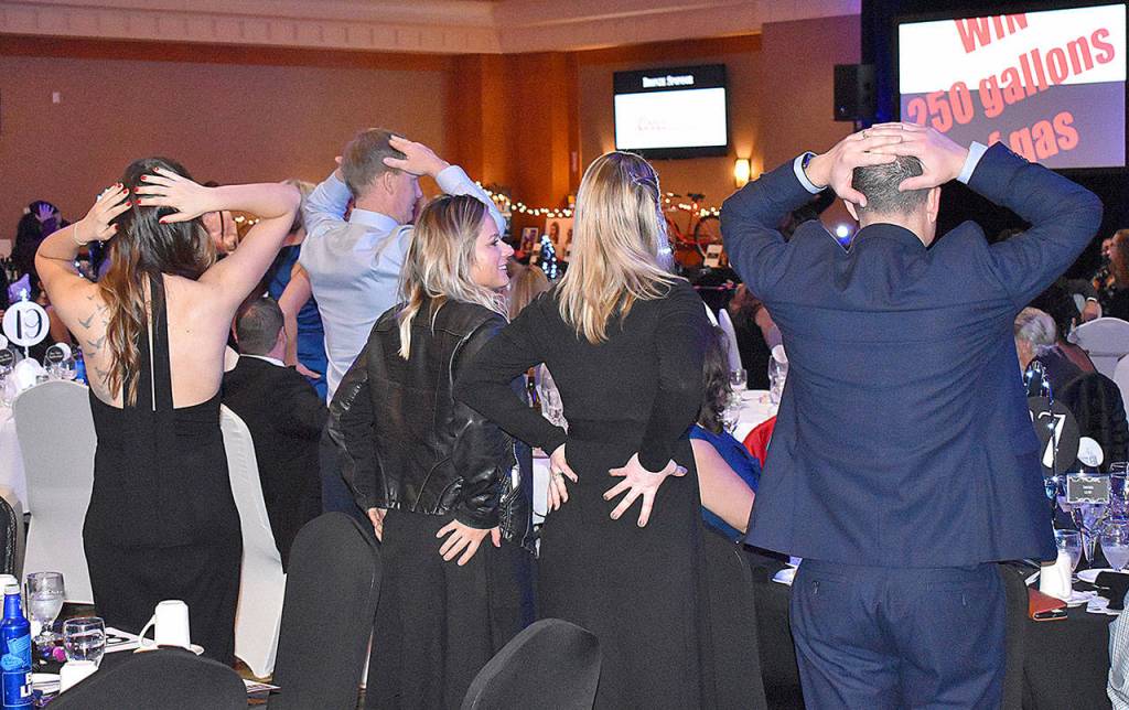 DAN HAMMOCK | GRAYS HARBOR NEWS GROUP                                Participants in the Heads or Tails fundraiser vie for 250 gallons of gasoline courtesy Masco Petroleum by grabbing their heads or, well, tails, as the auctioneer flips a coin until one person is left standing.