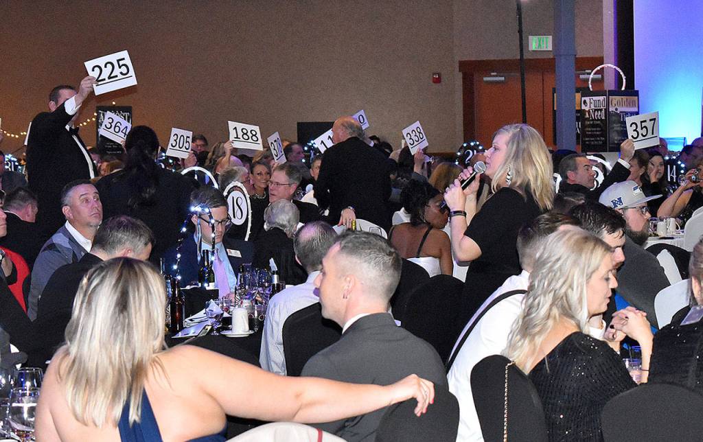 DAN HAMMOCK | GRAYS HARBOR NEWS GROUP                                During the Fund a Need portion of the Black and White Gala auction, attendees can donate at different levels toward United Way of Grays Harbors programs. Executive Director Kelley McDonald, with microphone, works the floor calling out bid numbers.