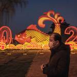 Nicolas Asfouri | AFP | Getty Images                                A man wears a protective facemask as he walks near the Forbidden City at a New Year installation in Beijing.