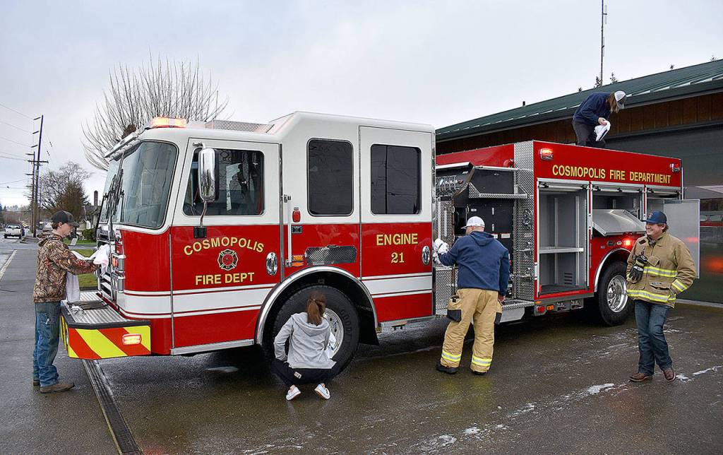 DAN HAMMOCK | GRAYS HARBOR NEWS GROUP                                 Volunteer firefighters put a shine on the Cosmopolis Fire Departments new engine at the station Sunday morning.
