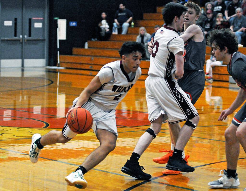 Ocosta point guard Cesar Martinez, left, drives around a screen set by teammate Kyle Wardlow during Tuesdays 2B District 4 play-in game on Tuesday in Westport. (Ryan Sparks | Grays Harbor News Group)