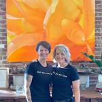 Trina (left) and Tammy Moore, co-owners of the Moore Gallery, in front of one of Trinas larger paintings. (Photo courtesy Trina Moore)