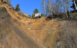 DAN HAMMOCK | GRAYS HARBOR NEWS GROUP                                 Demolition of the house at 432 Beacon Hill Drive in Hoquiam, hanging precariously over the slide that rendered it uninhabitable in January 2015, begins today.