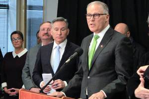 Gov. Jay Inslee (right) speaks at a press conference Wednesday in Seattle, alongside, from left, Everett Mayor Cassie Franklin, Snohomish County Executive Dave Somers and King County Executive Dow Constantine. (Joey Thompson/The Herald)