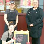 Asher Holcomb photo                                Genes Stop & Go owner/operator Ginger Holcomb, standing at left, has set up a voucher board to give her customers a way to help their neighbors in need. Shes pictured here with her crew: daughter Macy Holcomb, left, and Stephanie Larsson.