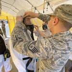 Air National Guard photo by Master Sgt. Michael Stewart                                 Airmen deployed from the 141st Air Refueling Wing at Fairchild Air Force Base in Spokane prepare to start a shift in the testing tent at the COVID-19 community based testing site in Aberdeen April 16. Twenty-seven Washington Air and Army Guardsmen are working together at the site.