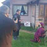 Lin Messerer photo                                 Hoquiam High School Principal Brock Maxwell conducts a mini graduation ceremony for senior Rashelle Bates on her front lawn as her mother, Rhea Abbott, watches from her bed inside.