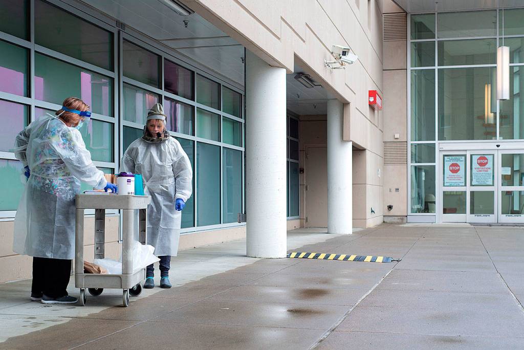 Melanie Brandt, left, chief nursing officer of Grays Harbor Community Hospital, takes a turn at one of the hospitals entrance screening stations with Registered Nurse Chrissy Boice.