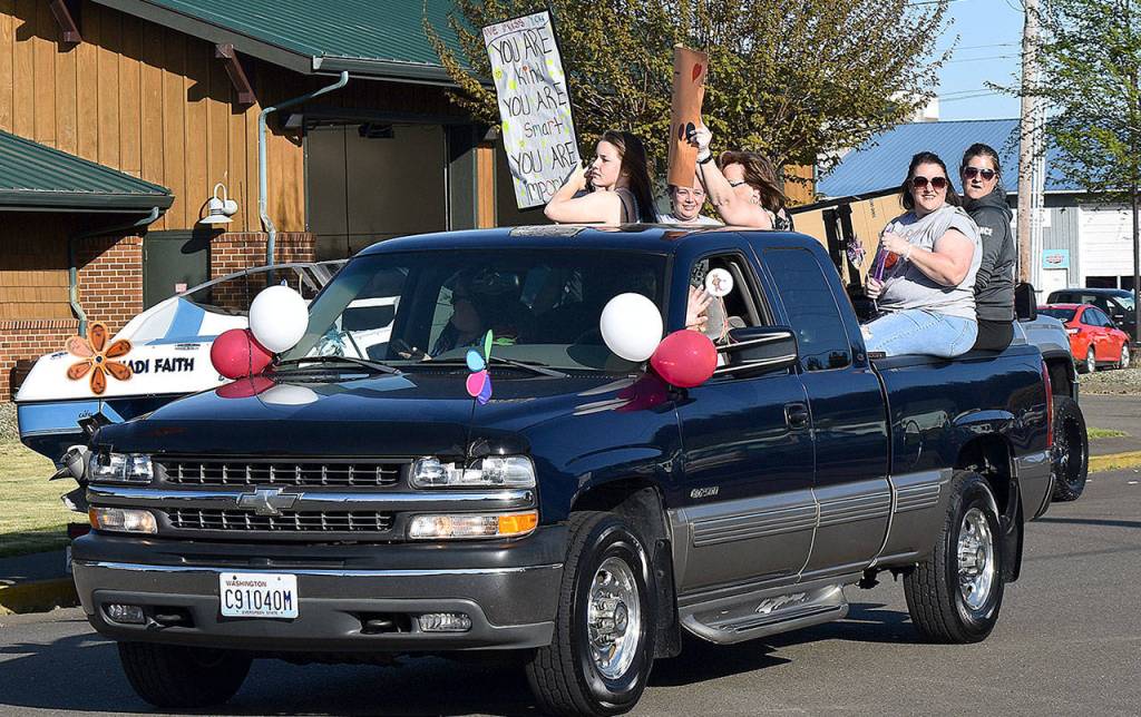 DAN HAMMOCK | GRAYS HARBOR NEWS GROUP                                 This trucks passengers held signs for the students of Cosmopolis during Fridays parade. One read, We miss you. You are kind. You are smart. You are important. Signs on the citys new fire truck included, Cosi Cougars are #1 and Cosi kids rock!