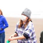 Dalin DAlessandro, a Portland State University research assistant heads to wash her face after the whales liver unexpectedly burst in front of her durung the necropsy.