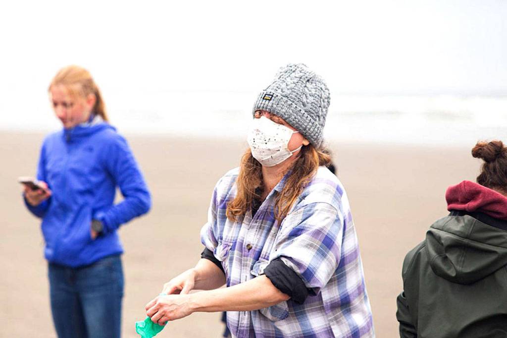 Dalin DAlessandro, a Portland State University research assistant heads to wash her face after the whales liver unexpectedly burst in front of her durung the necropsy.