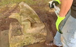 KAT BRYANT | THE DAILY WORLD                                 After cleaning off the top layer of dirt and heavy moss, much work remained to be done in restoring Lance Wood Harts headstone.