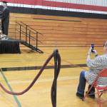 Kat Bryant | Grays Harbor News                                Group Joseph Gilbert receives his diploma cover from Ocosta School Board President Greg Miller in a mostly empty gym on Saturday, with family members seated up front to cheer him on and take photos. At the podium is Principal Chris Pollard.