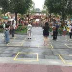 Yellow boxes are taped on the ground to maintain social distancing between audience members inside the park. One family is allowed to stand in each box. (Alice Su/Los Angeles Times)